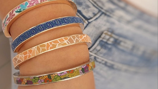 Close-up of a wrist wearing colorful patterned bracelets on a blurred background